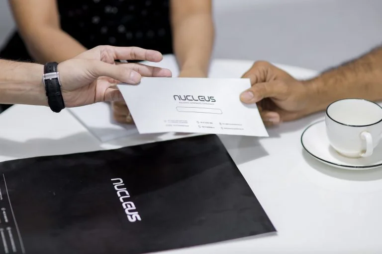 A Nucleus consultant handing over booking documents to a client
