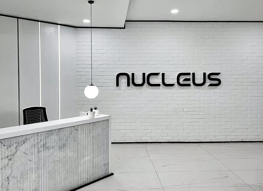 Nucleus office reception with white brick wall and marble desk
